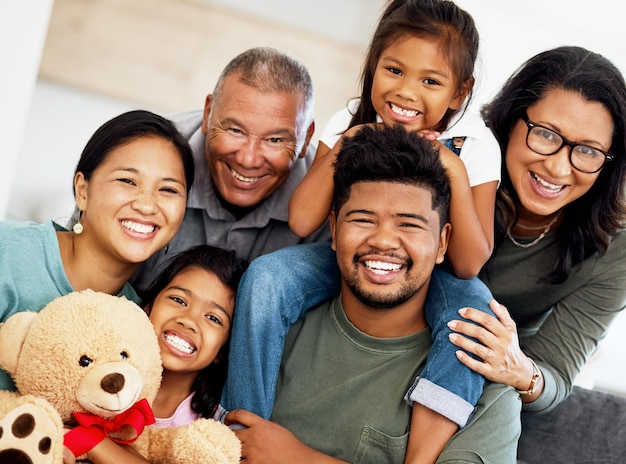 Foto retrato feliz de la casa familiar y abuelos en la sala de estar con niños sonriendo durante la visita a casa y cuidando en el sofá en el salón juntos hermanos africanos padres y ancianos en el sofá