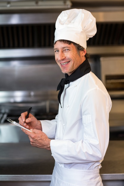 Retrato de feliz chef masculino en cocina