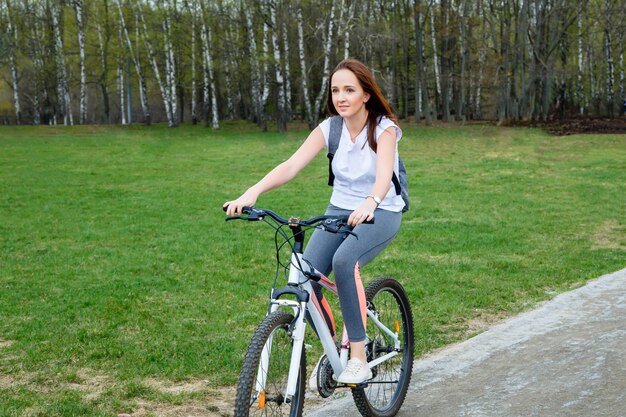 Retrato de feliz ciclista joven en el parque