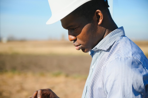 Retrato de feliz construcción africana con casco