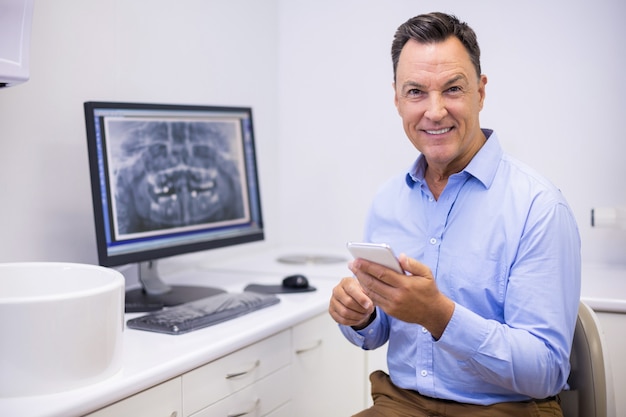 Retrato de feliz dentista mediante teléfono móvil