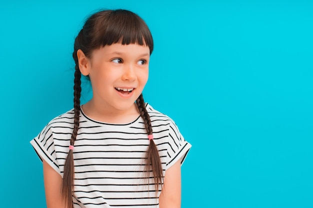 Retrato de feliz emocionado asombrado boca abierta niño niña morena vestido a rayas mirar en copyspace