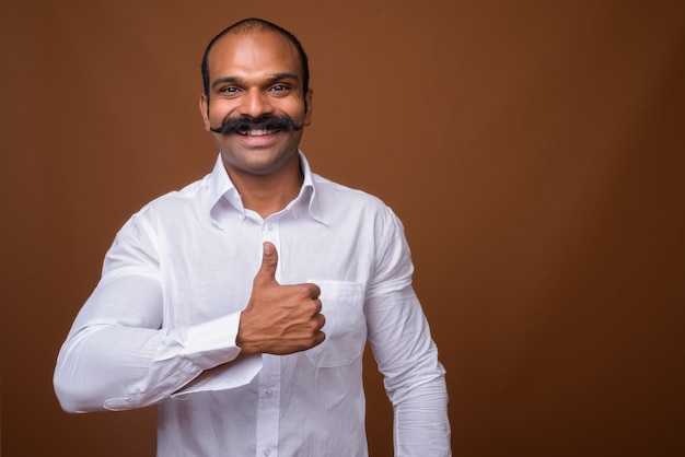 Retrato de feliz empresario indio con bigote en ropa casual