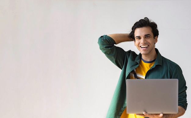 Foto retrato de feliz estudiante masculino con laptop mirando a cámara y sonriendo, espacio de copia