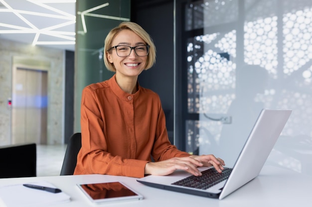 Retrato de una feliz y exitosa programadora dentro de la oficina del trabajador del lugar de trabajo sonriendo y