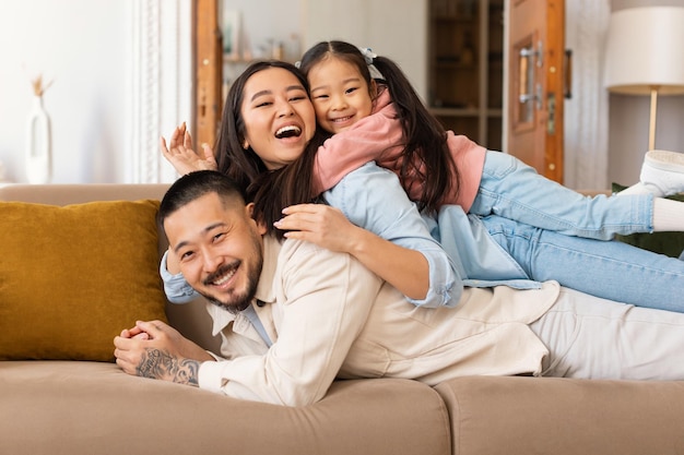 Retrato de una feliz familia japonesa amontonada en casa
