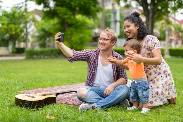 Retrato de feliz familia multiétnica con un niño que se unen al aire libre