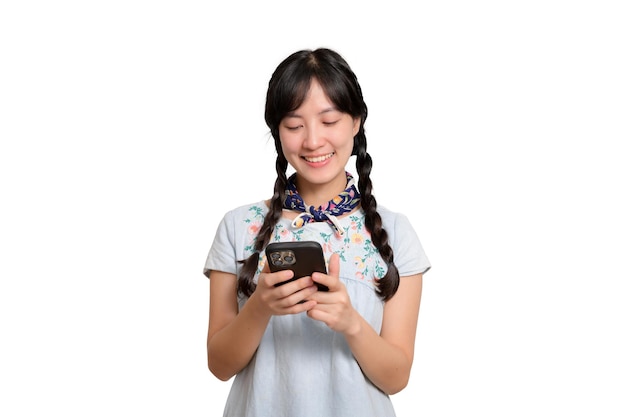 Retrato de feliz y hermosa mujer asiática joven en vestido de mezclilla usando un teléfono inteligente en una foto de estudio de fondo blanco