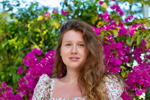 Retrato de feliz hermosa niña joven mujer positiva está oliendo hermosas flores rosas en el