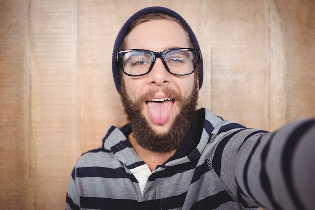 Retrato de feliz hipster sacando la lengua