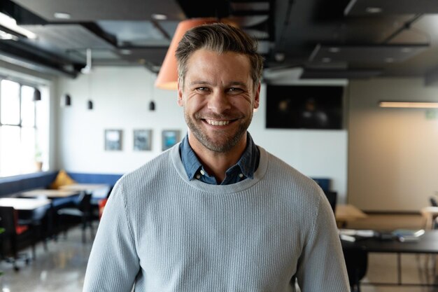Retrato de feliz hombre de negocios caucásico adulto medio en oficina creativa