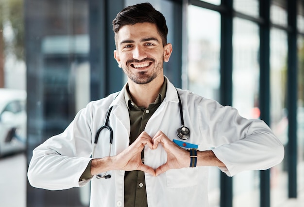 Retrato feliz, homem, médico e coração, mãos para cuidados de saúde, amor, serviço médico, confiança e suporte hospitalar Ícone de saúde de emoji de cardiologia e cirurgião masculino para ajuda de clínica de bem-estar ou seguro de vida