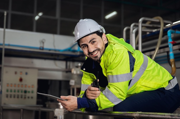 Retrato feliz ingeniero trabajador de fábrica capataz supervisor trabajando en la industria pesada sentado relajarse sonriendo mirando la cámara