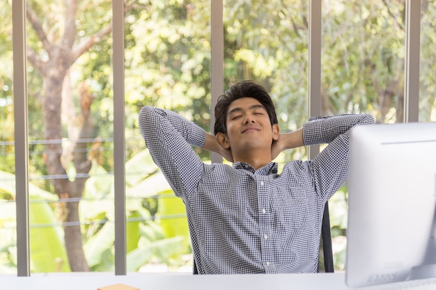 Retrato de feliz inteligente joven empresario asiático sonrisa y emoción alegre y sala de descanso con computadora de escritorio en la sala de trabajo de la oficina.