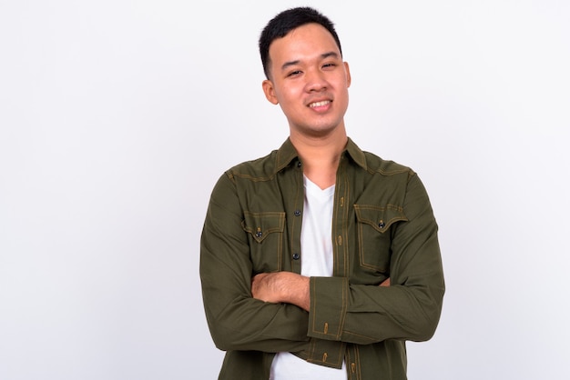 Retrato de feliz joven asiático sonriendo con los brazos cruzados