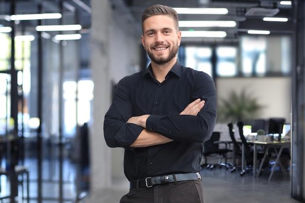 Retrato de un feliz joven empresario casual en la oficina