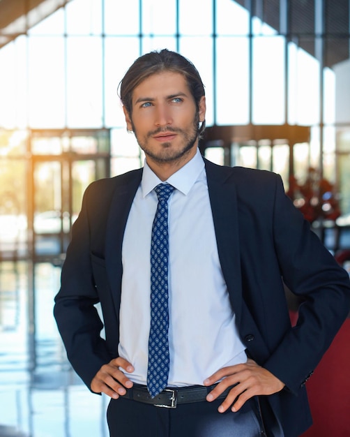 retrato, de, feliz, joven, hombre de negocios, posición, en, hotel, vestíbulo