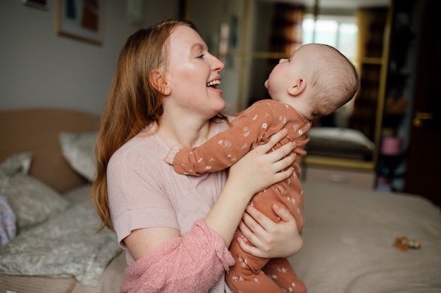 Retrato de feliz joven madre con bebé en brazos El concepto de una familia feliz