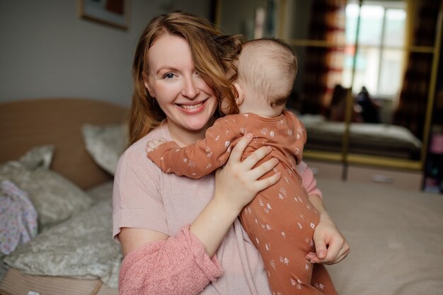 Retrato de feliz joven madre con bebé en brazos El concepto de una familia feliz