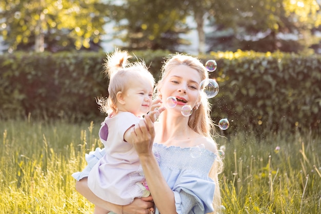 Retrato de feliz joven madre con hijita linda pasar tiempo juntos