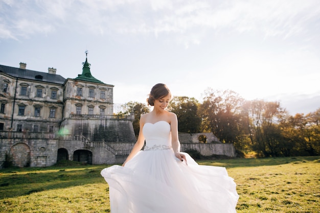 Retrato de feliz joven novia en vestido blanco