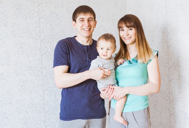 Retrato de feliz joven padre, madre y bebé.