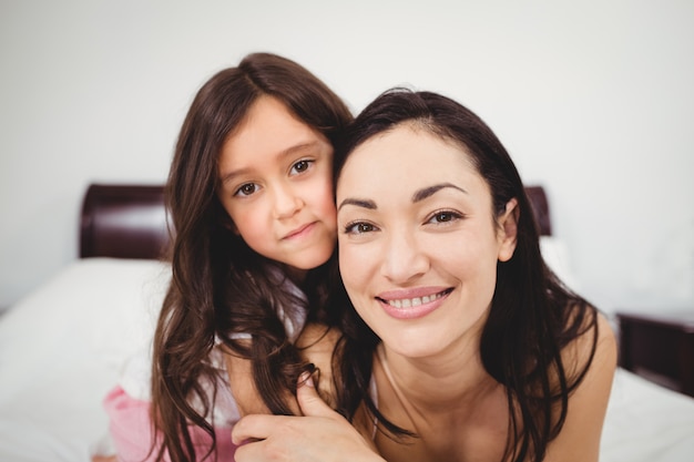 Retrato de feliz madre e hija en casa