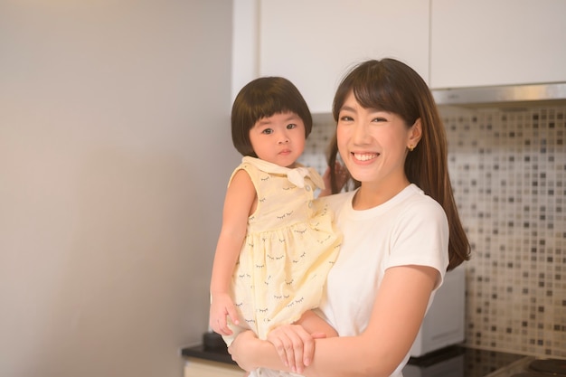 Un retrato de feliz madre e hija en la cocina de casa