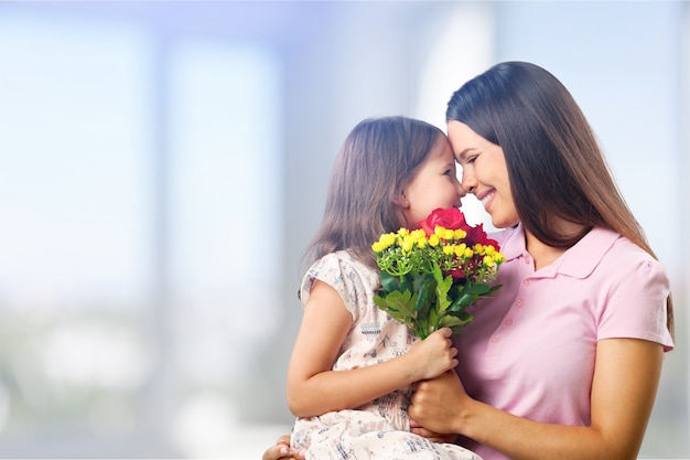 Foto retrato de feliz madre e hija sosteniendo flores