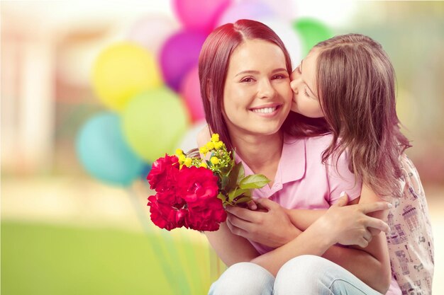 Retrato de feliz madre e hija sosteniendo flores