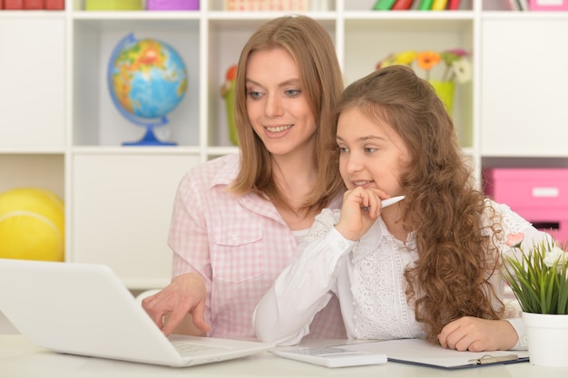 Foto retrato, de, feliz, madre e hija, usar la computadora portátil