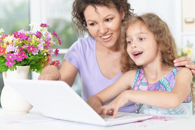 retrato, de, feliz, madre e hija, usar la computadora portátil