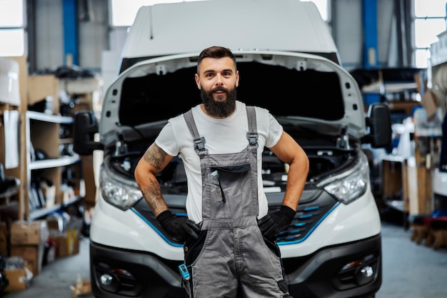 Retrato de feliz mecánico de automóviles en el taller