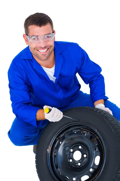 Foto retrato de feliz mecánico trabajando en neumático