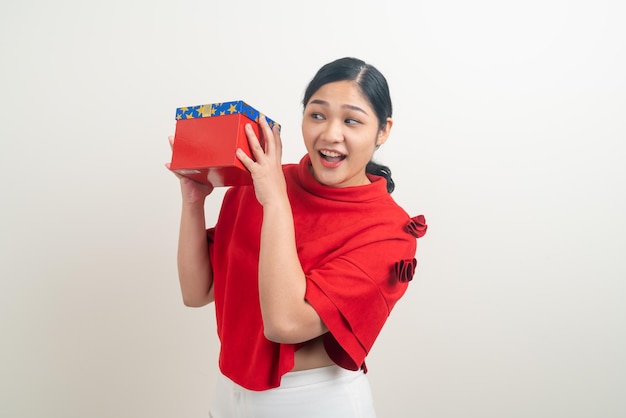 retrato feliz mujer asiática con camisa roja con caja de regalo a mano para el festival de Navidad