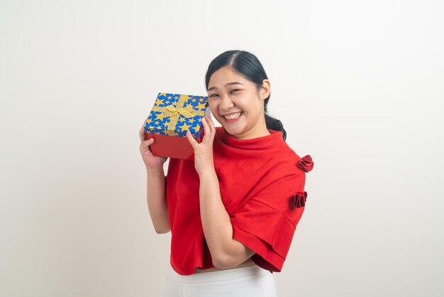 Retrato feliz mujer asiática vistiendo camisa roja con caja de regalo a mano para el festival de Navidad