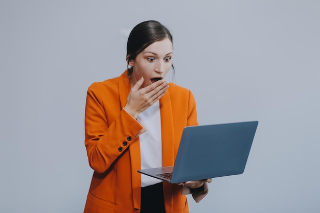 Retrato de una feliz mujer de negocios asiática trabajando en una computadora portátil aislada sobre un fondo blanco