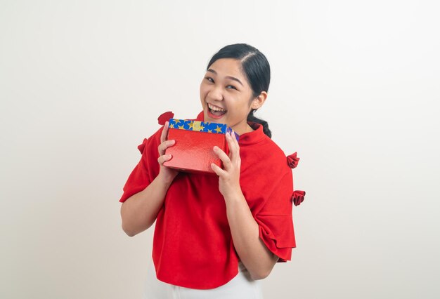 retrato feliz mulher asiática vestindo uma camisa vermelha com uma caixa de presente disponível para o festival de Natal