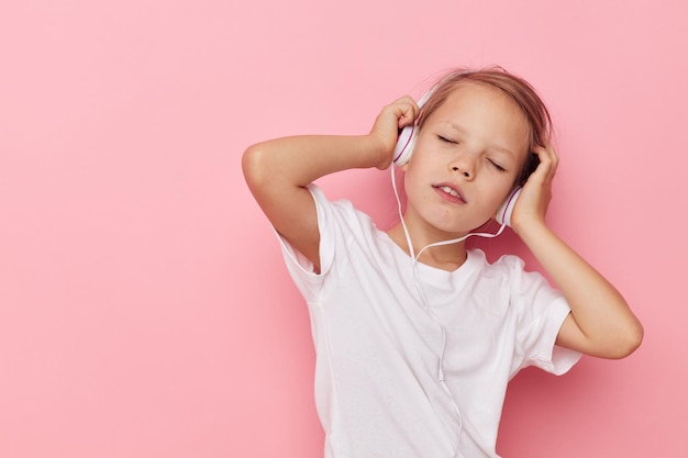 Retrato de feliz niña sonriente niño divertido posando auriculares infancia inalterada