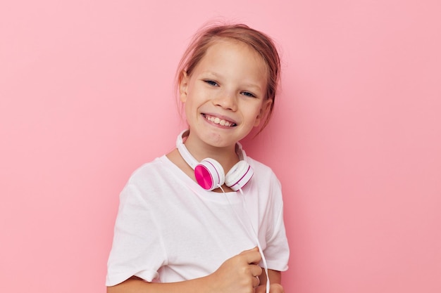 Retrato de feliz niña sonriente niño divertido posando auriculares infancia inalterada