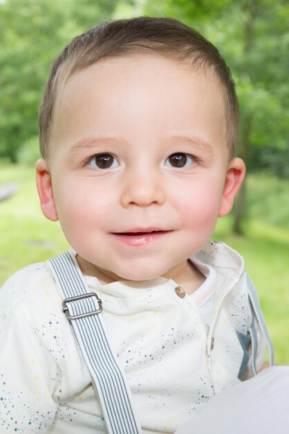 Retrato feliz para un niño en un parque verde