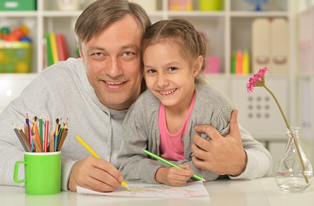 Retrato de feliz padre e hija pintando en casa