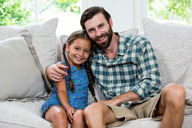 Retrato de feliz padre con hija en el sofá