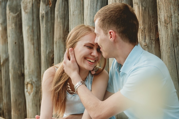 Retrato de la feliz pareja abrazándose riendo fondo de madera