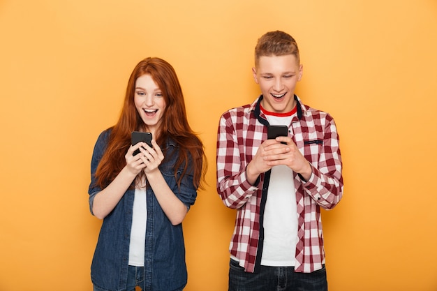 Retrato de una feliz pareja de adolescentes mediante teléfono móvil