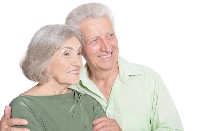 Retrato de una feliz pareja de ancianos abrazando sobre un fondo blanco.