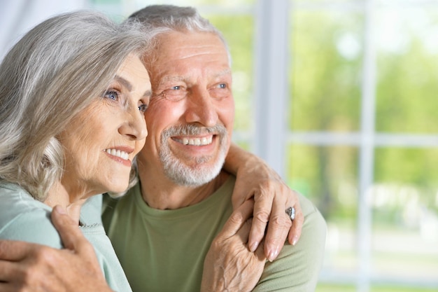 Retrato de una feliz pareja de ancianos abrazándose en casa