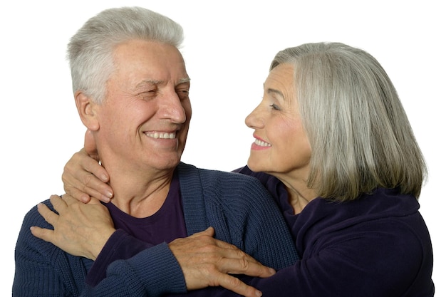 Retrato de una feliz pareja de ancianos abrazándose sobre un fondo blanco.