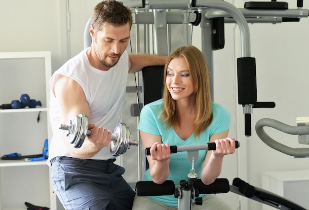 Retrato de una feliz pareja atractiva en el gimnasio