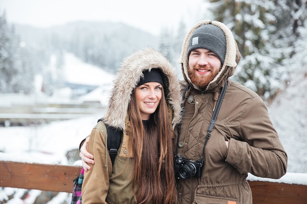 Retrato de la feliz pareja joven con cámara de fotos en Winter Mountain Resort